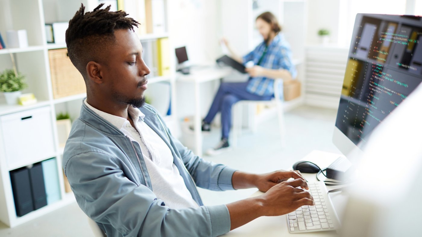 ting by desk, typing and coding data or analyzing new database