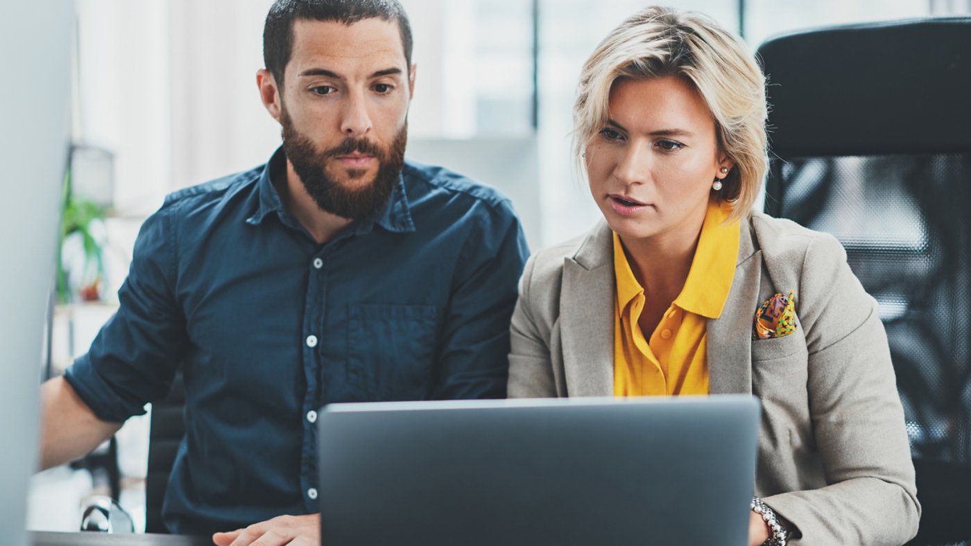 Group of young confident coworking people using computer while working time in the office