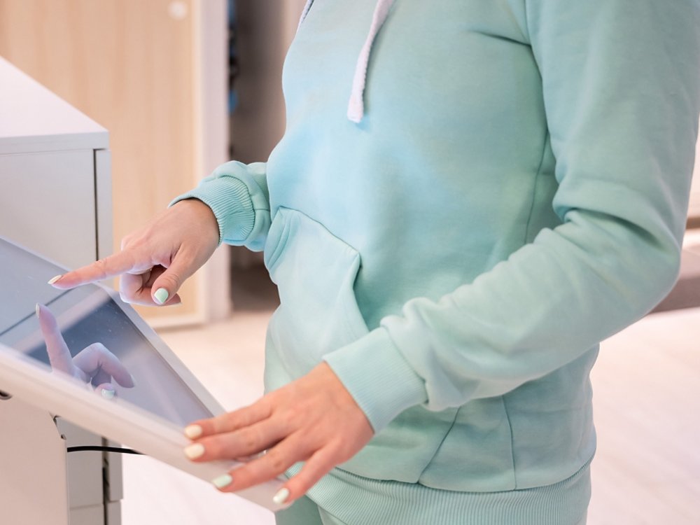 Faceless woman touching the screen of a self-service device in a store. Device store navigator. Self purchase