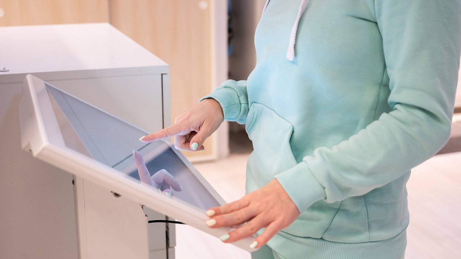 Faceless woman touching the screen of a self-service device in a store. Device store navigator. Self purchase