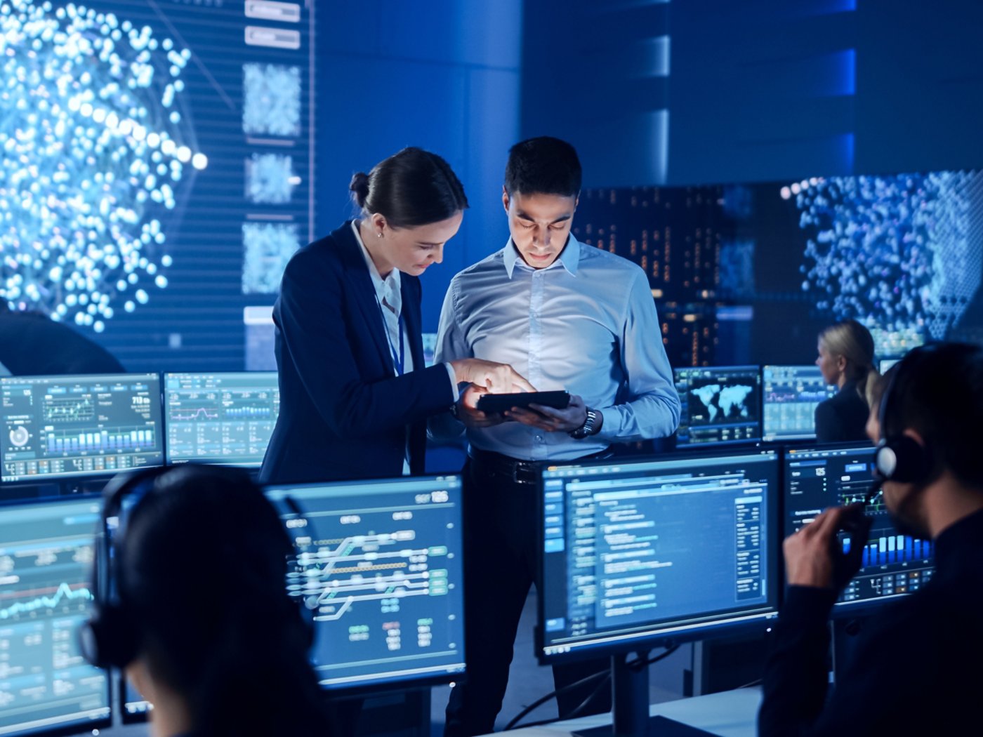 Project Manager and Computer Science Engineer Talking while Using A Digital Tablet Computer. Telecommunications Company System Control and Monitoring Office Room with Working Specialists.