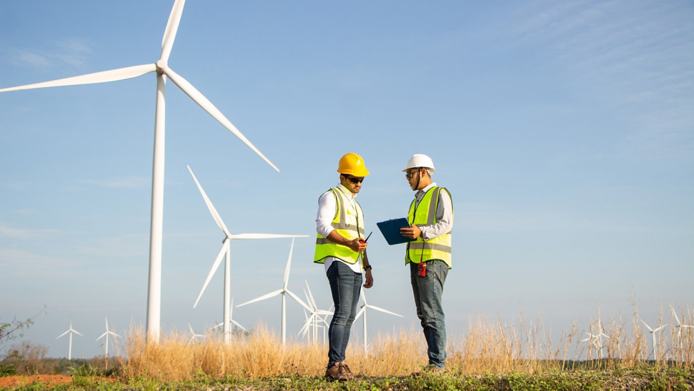 engineer team working in wind turbine farm. Renewable energy with wind generator by alternative energy concept.