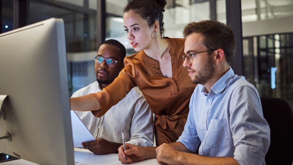 Learning, computer and training business interns in night office with manager, boss and leadership help. Men with technology planning ideas, kpi strategy and marketing innovation vision with mentor