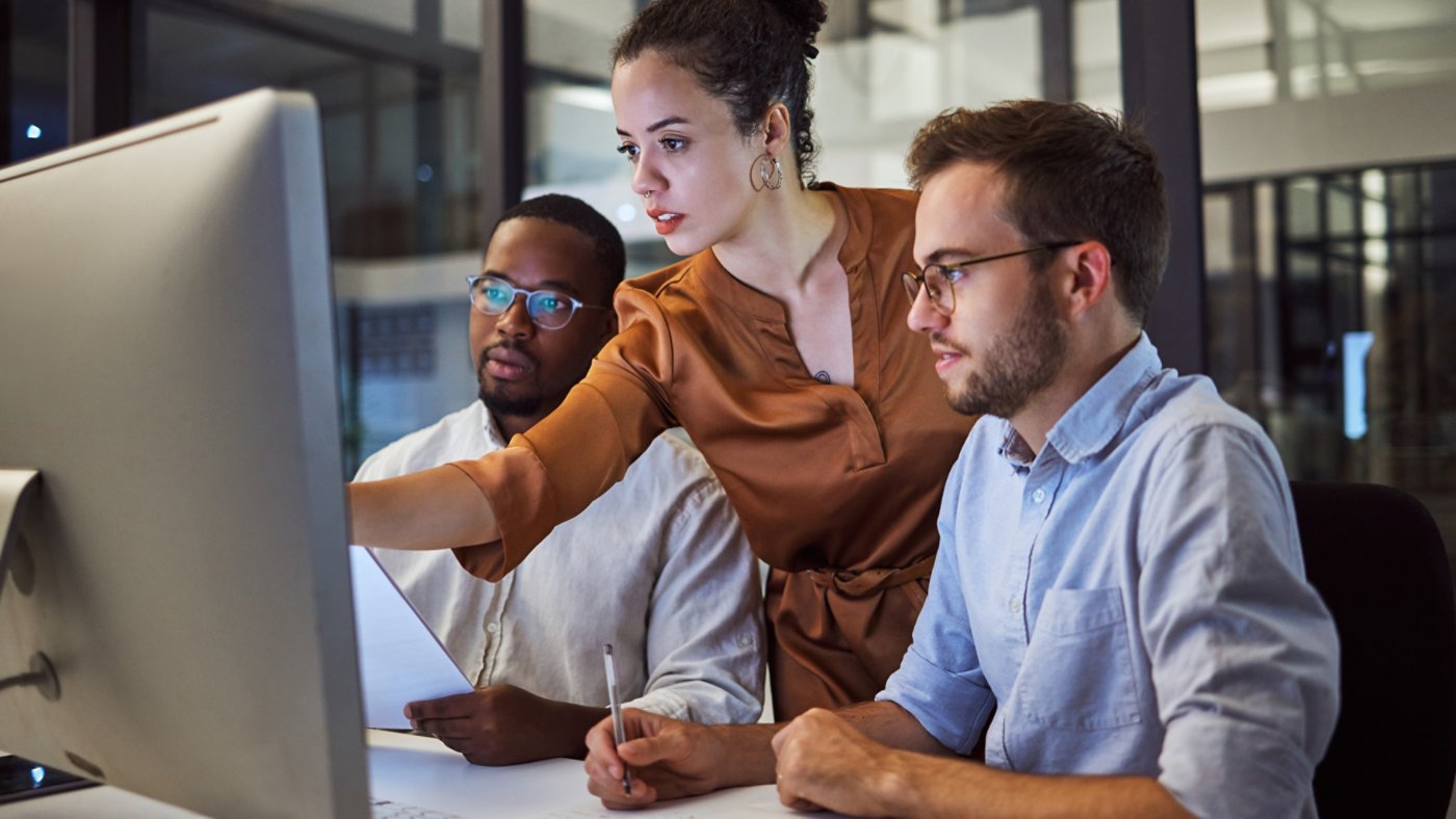 Learning, computer and training business interns in night office with manager, boss and leadership help. Men with technology planning ideas, kpi strategy and marketing innovation vision with mentor