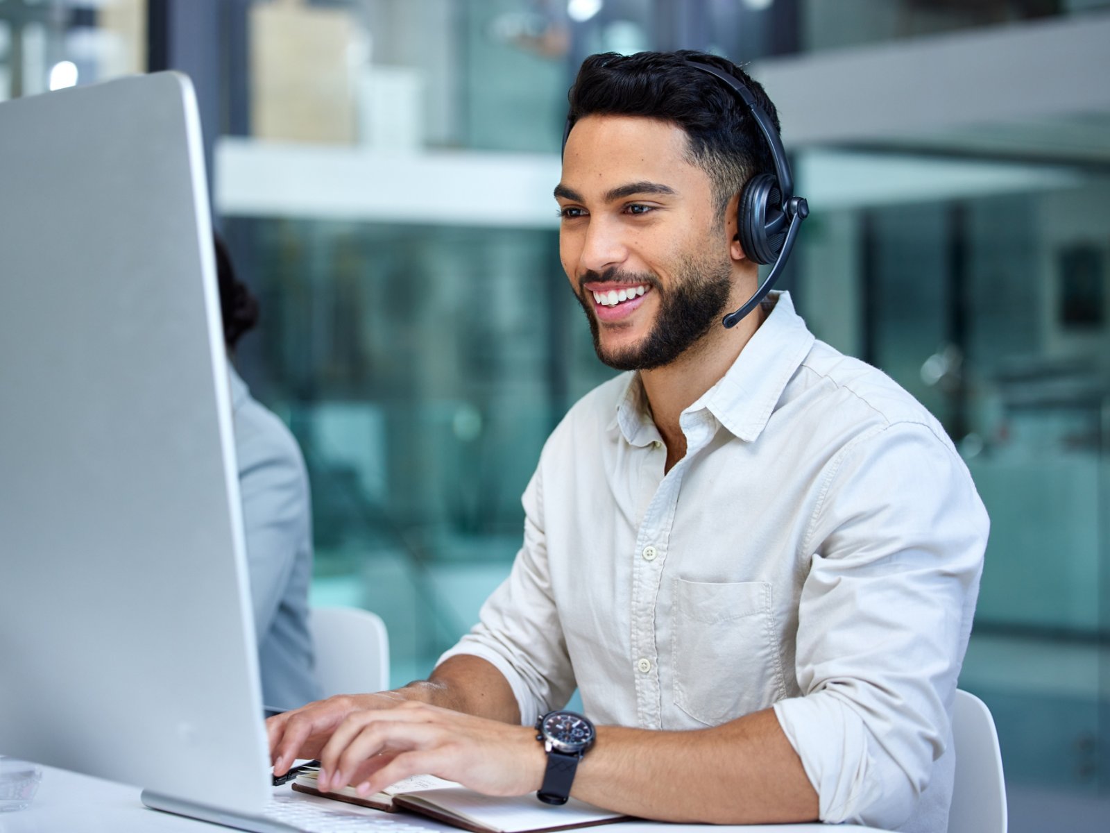 Business man, call center and web support communication at a computer in a office. Phone conversation, smile and male worker with contact us, crm and customer service job in a consulting agency