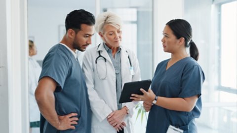 Doctor, team and tablet in discussion with senior for healthcare training, advise or support at hospital. Medical professionals with touchscreen in conversation, collaboration or teamwork at clinic.