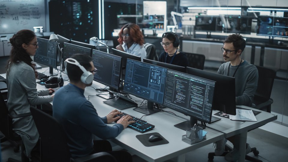 Team of Talented Young Professionals Working in a Technological Research and Development Agency. Computer Screens with Software Code, Customer Relationship Management Tool and Road Map User Interface