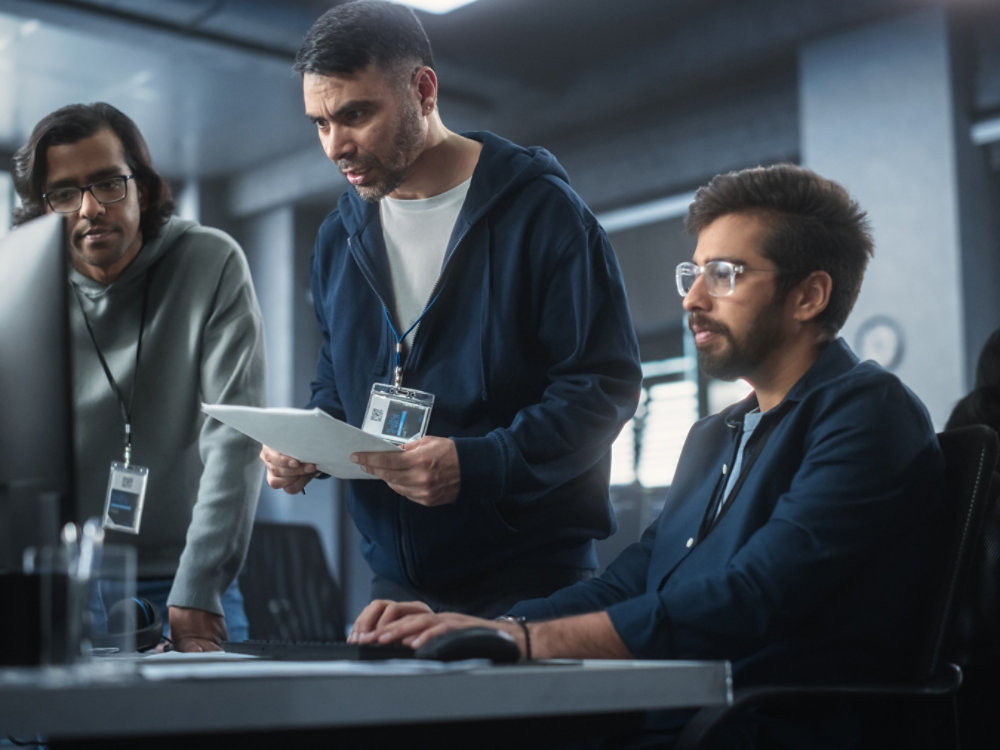 Team of Three Multiethnic Diverse Software Developers Talk, Discuss and Collaborate on an AI Project. Empowered Young Indian Specialists Work on Digital E-Commerce Startup Business