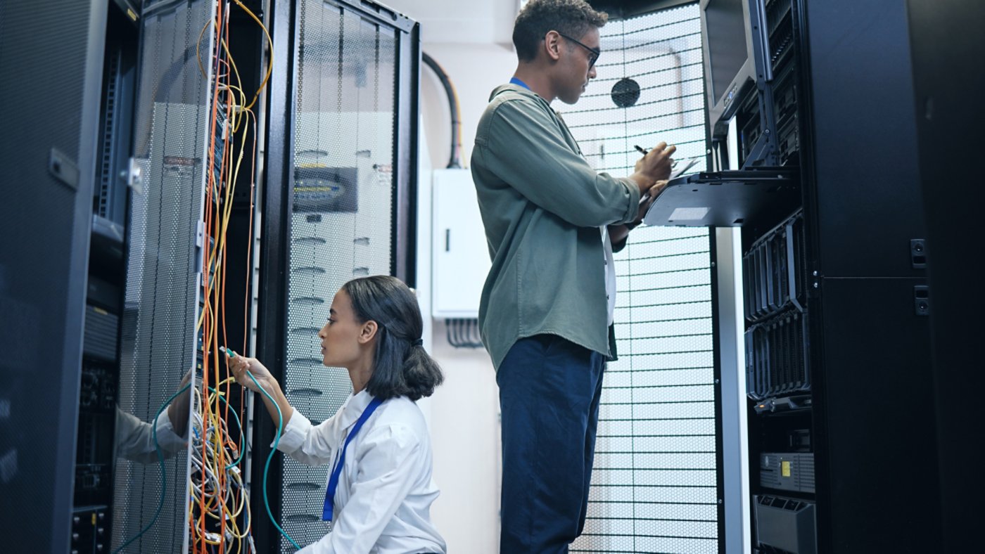 Server room, engineer and IT team with a tablet for programming, cybersecurity or cable maintenance. Man and woman technician together in datacenter for network, software or system upgrade with tech