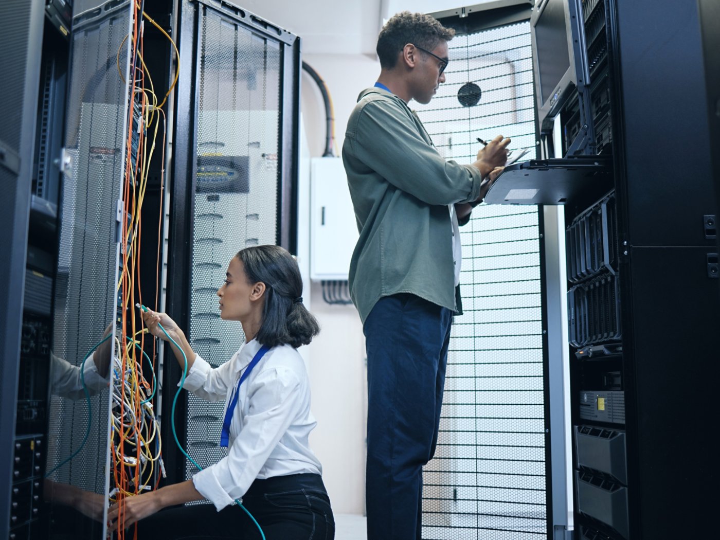Server room, engineer and IT team with a tablet for programming, cybersecurity or cable maintenance. Man and woman technician together in datacenter for network, software or system upgrade with tech