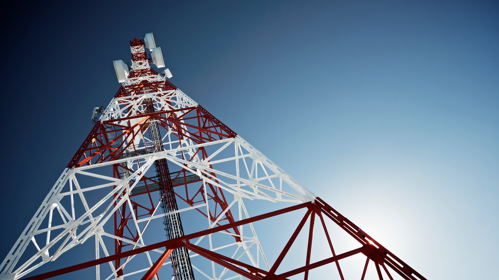 Telecommunications tower with clear blue sky.