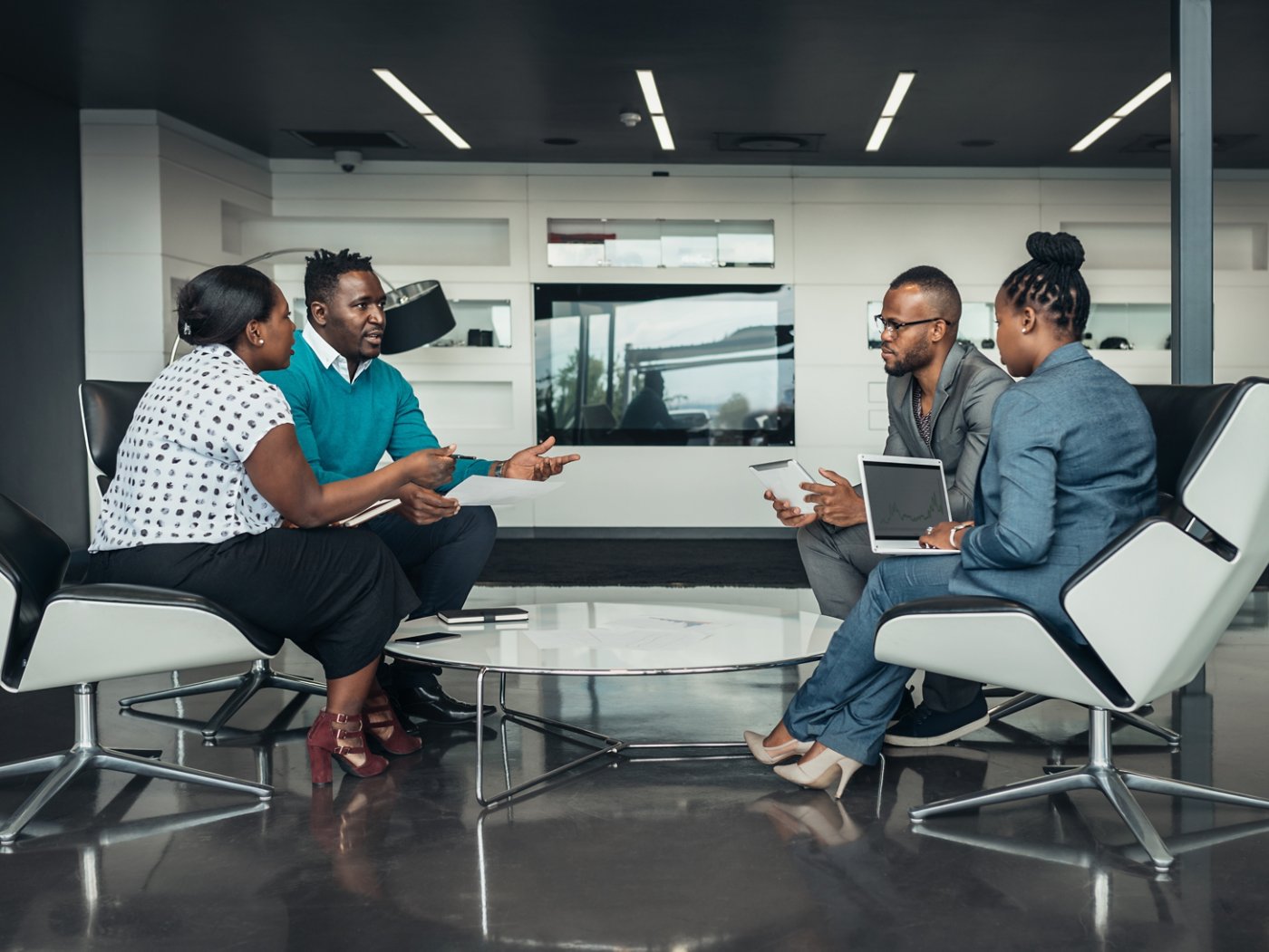 Team of african bussines people sitting in a modern office and talking during an work meeting