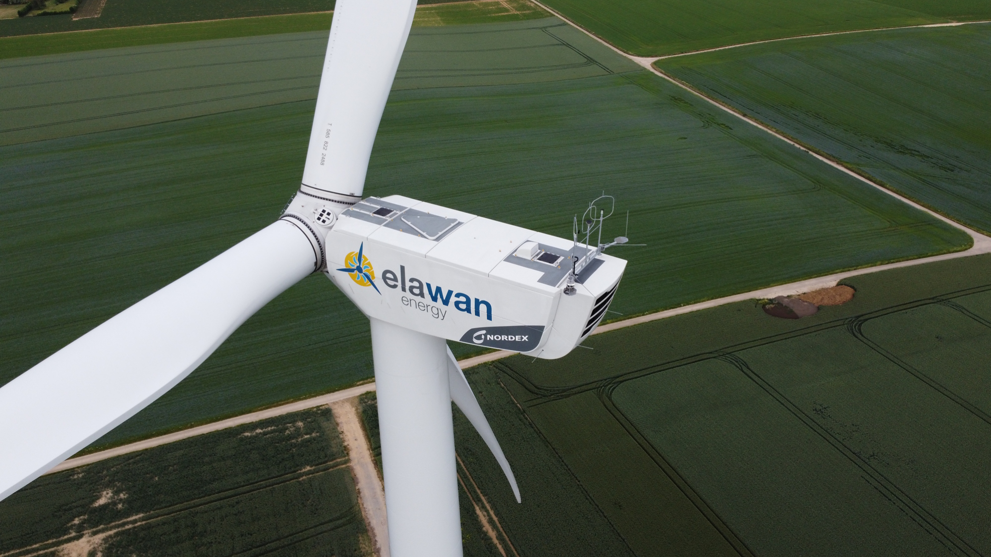 Windmill above green farmland