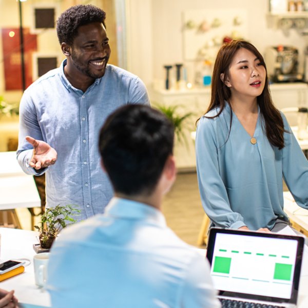 Group of young, modern people sitting on business meeting in modern coworking space and suggesting ideas for the best business strategy