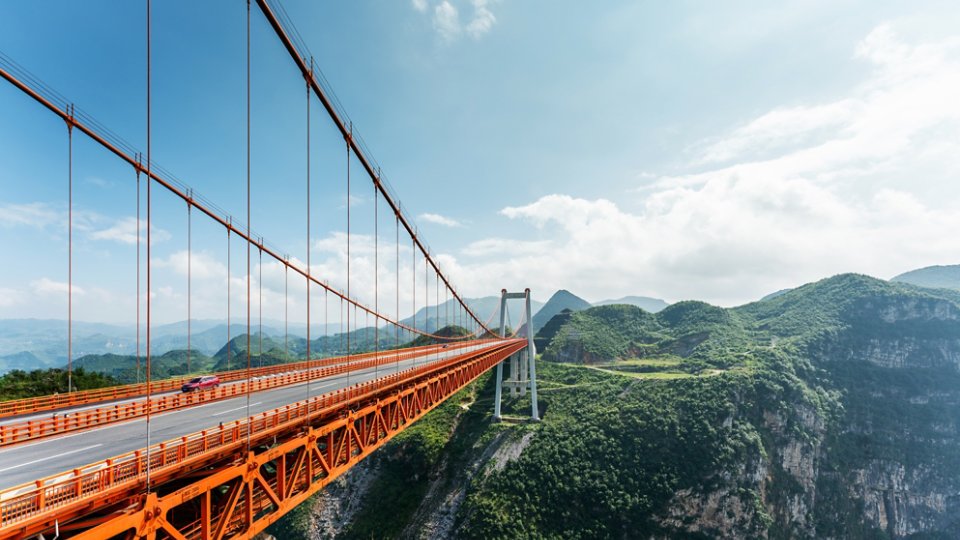 orange suspension bridge over a gorge