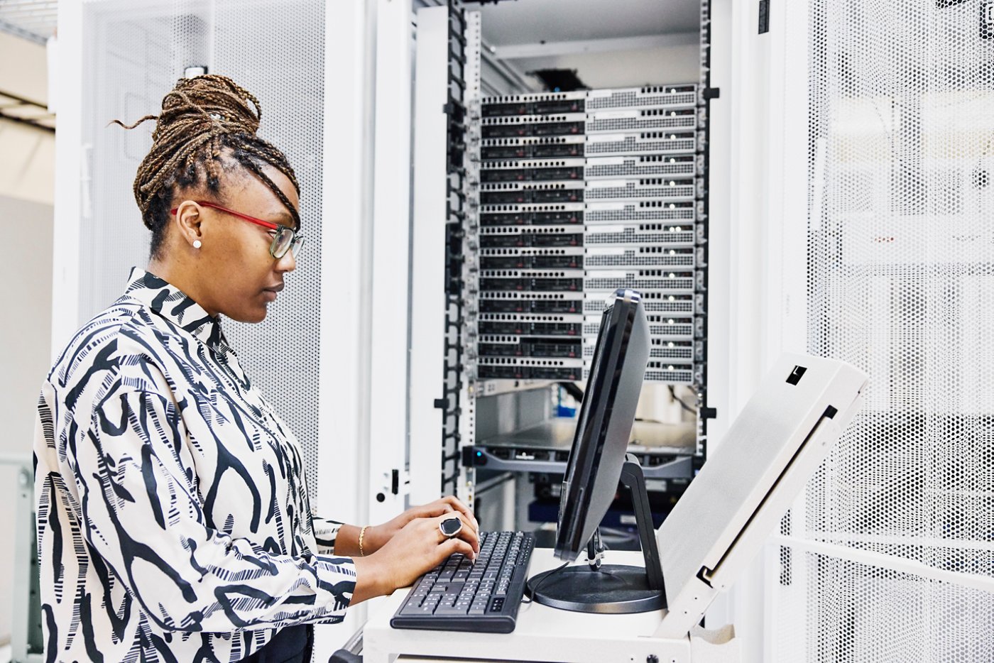Medium shot of female IT professional configuring server in data center