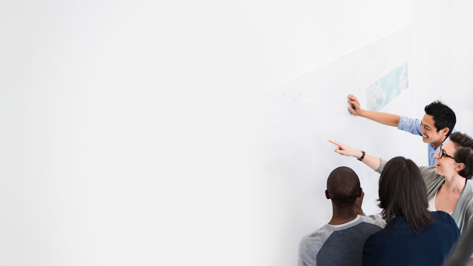 A photo of business people communicating over transparent board. High angle view of multi-ethnic professionals are planning in creative office. They are wearing smart casuals at workplace.