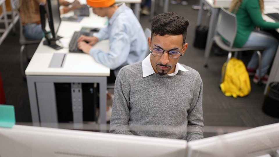 A still image of a young man working at a computer