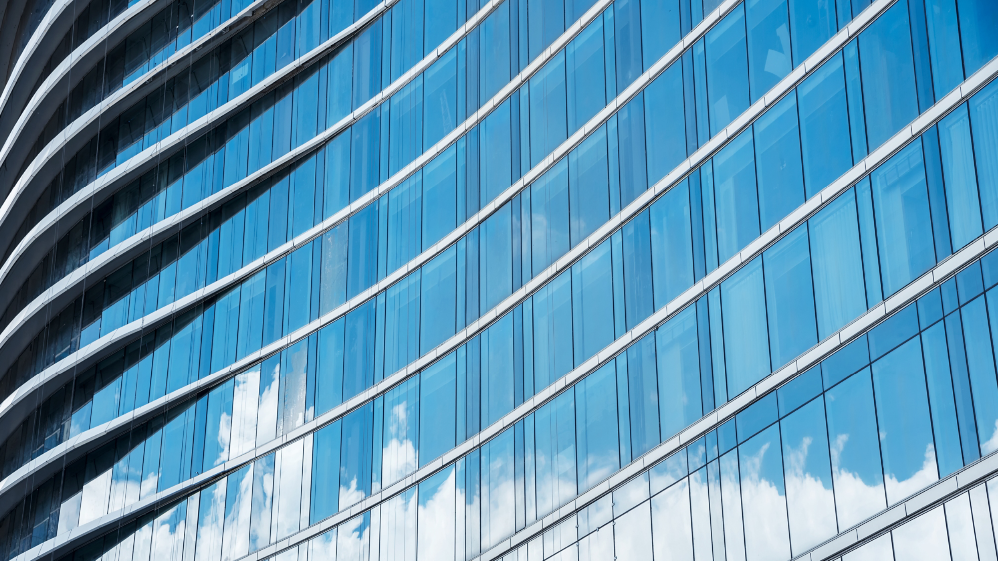 Pattern of blue glasses in high building with shadow of cloud. Abstract modern building background.