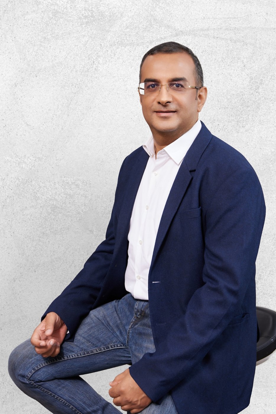 Image of Neeraj Malhotra, Singapore Client Unit Leader, sitting on a stool