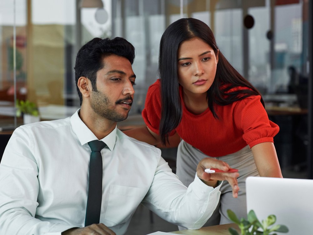 A businessman and a businesswoman looking at the laptop and discussing 4X3