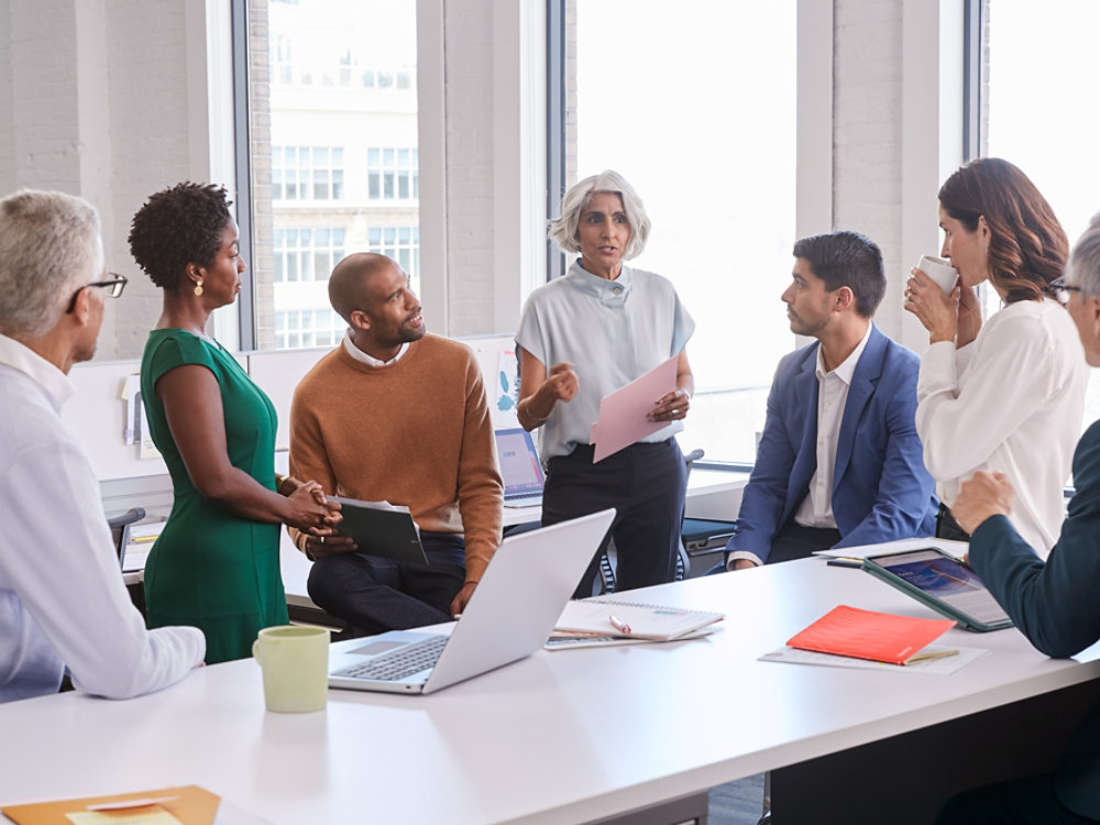 Group of multi ethnic business people standing and discussing business and reports 1X1