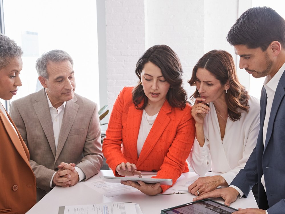 five multi ethnic business people discussing a business report