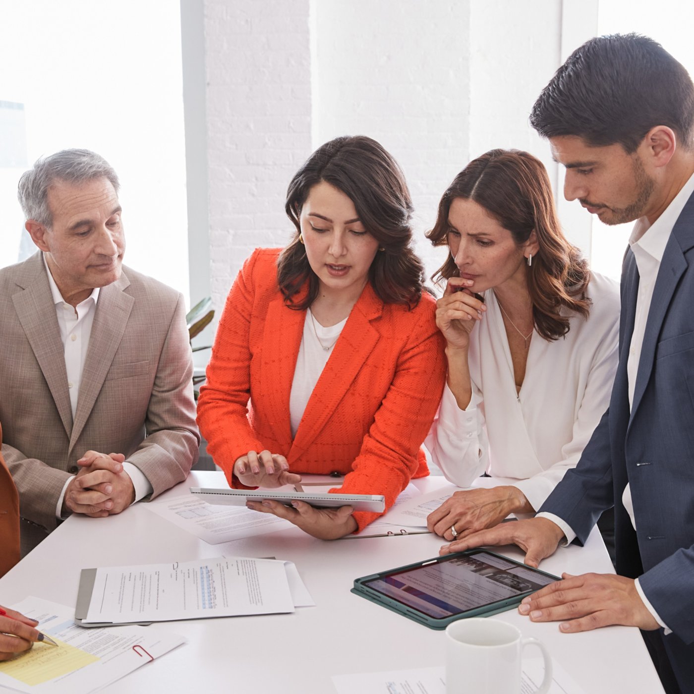 five multi ethnic business people discussing a business report
