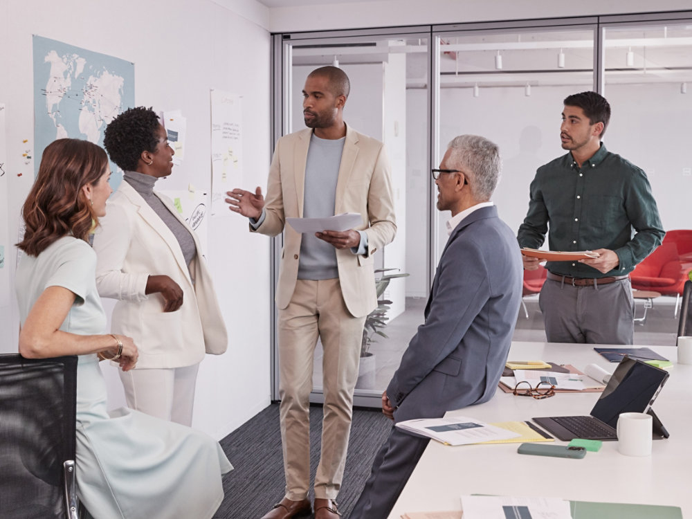 5 multi ethnic business people standing in a meeting room and discussing business operations 4X3