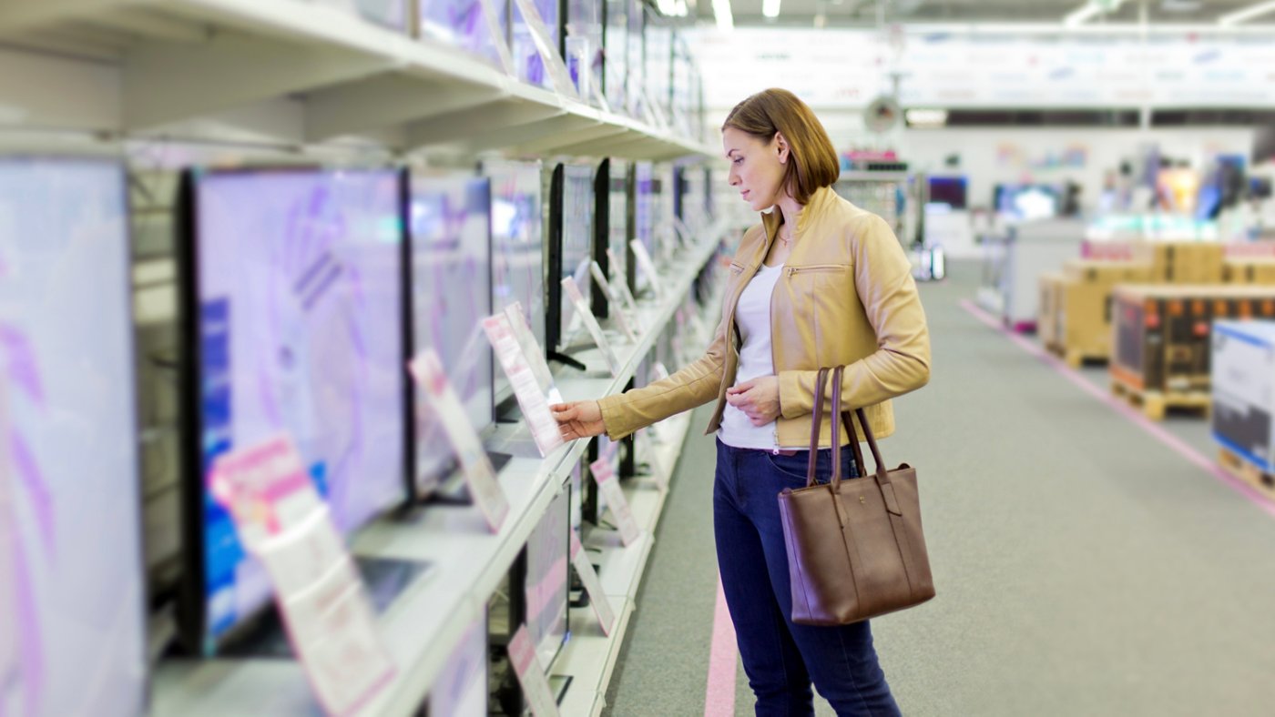 woman chooses a TV in the store