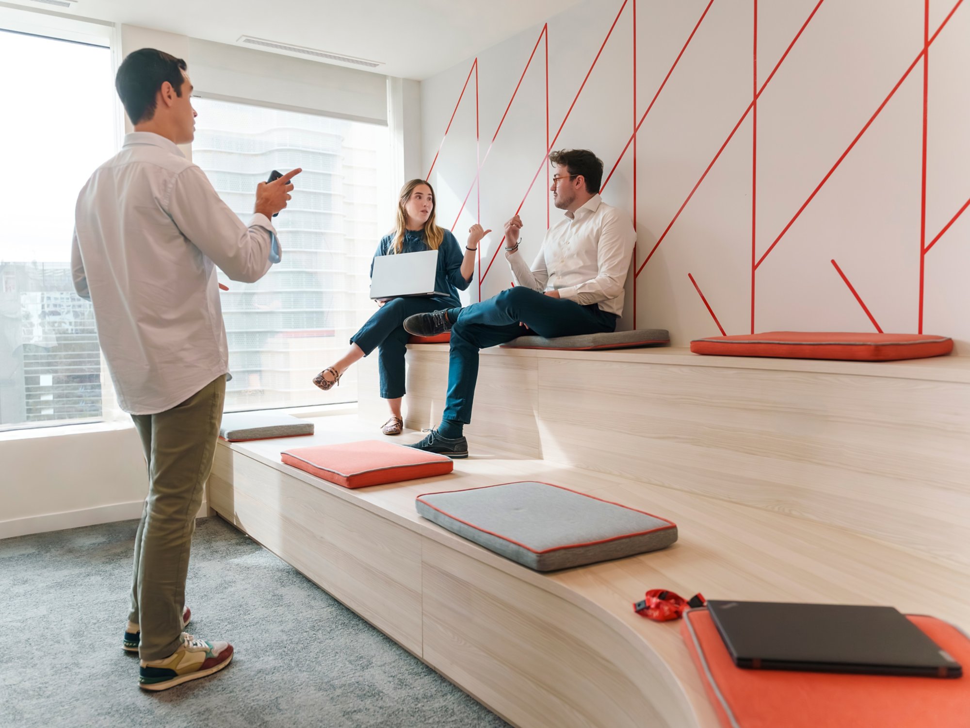 three young Kyndryl employees from Spain discussing a business project