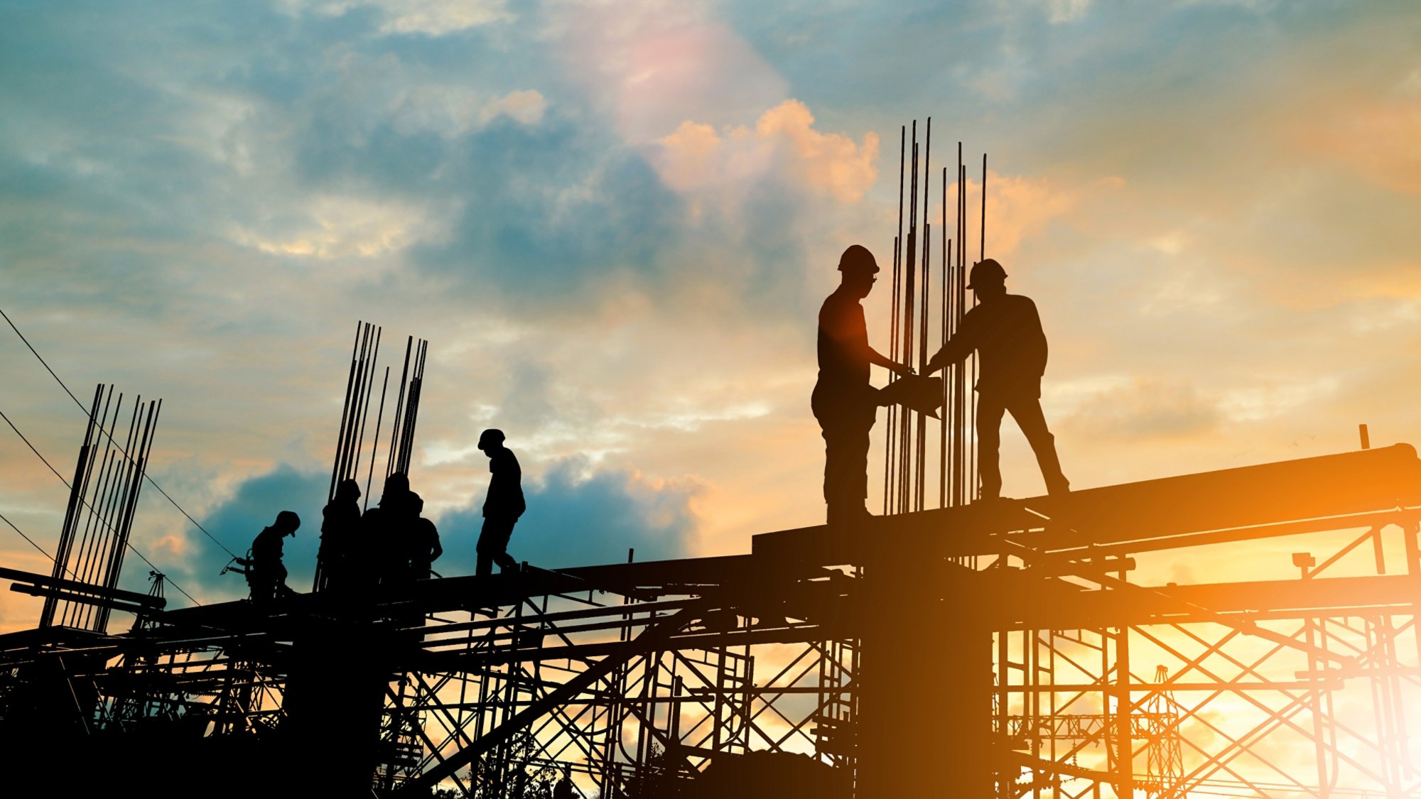 Silhouette of engineer and construction team working at site over blurred background sunset pastel for industry background with Light fair.