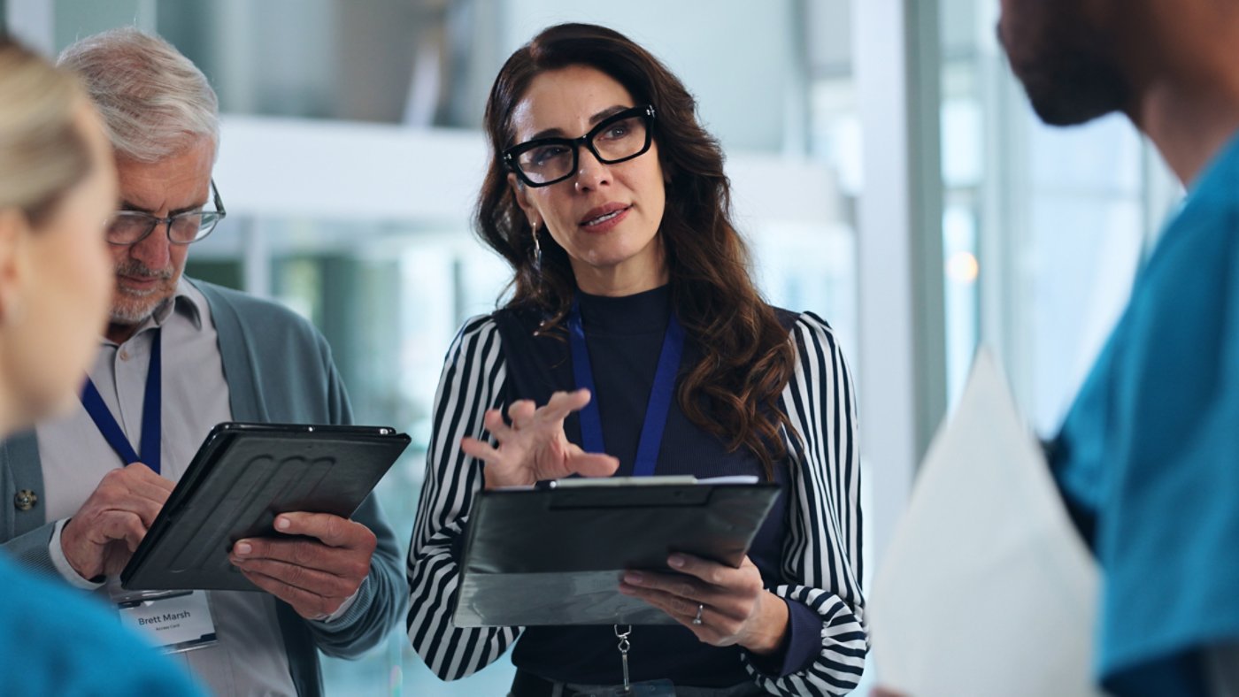 Business people discussing a project that is being carried out on company software upon their computer tablets