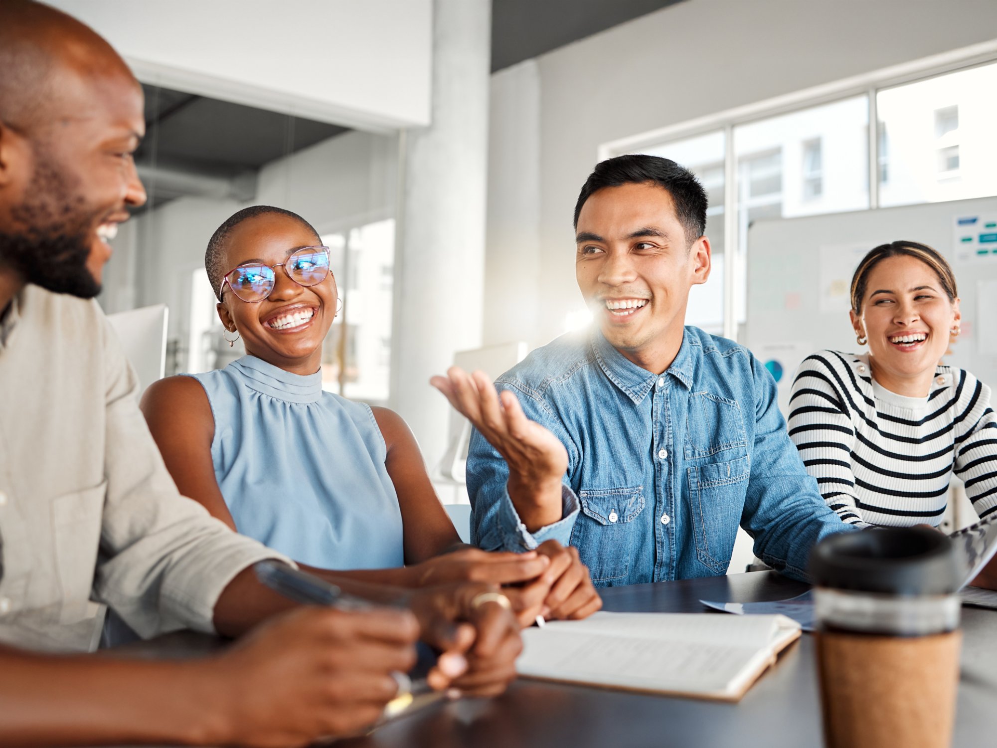 Business people, meeting and laugh in office with digital media management and group chat. Teamwork, conversation and online campaign launch and planning with laptop and diversity at startup
