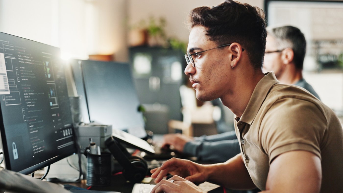 Computer, programming and web development with man in creative workplace for coding or design. Cybersecurity, language and system infrastructure with employee person in office as website developer