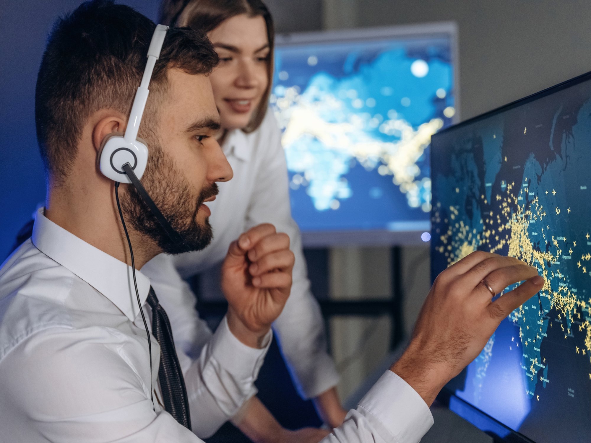 Looking at map together. People are working by computers in airline company