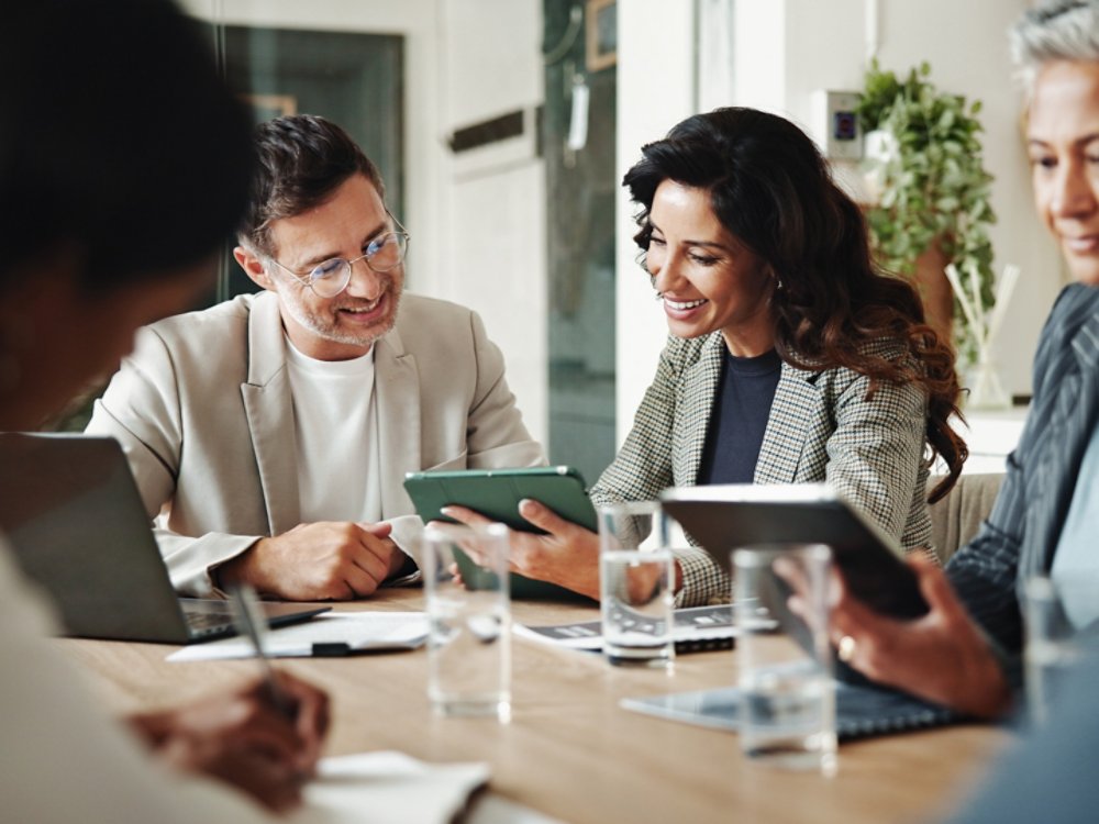 people in a business meeting looking at computer tablets