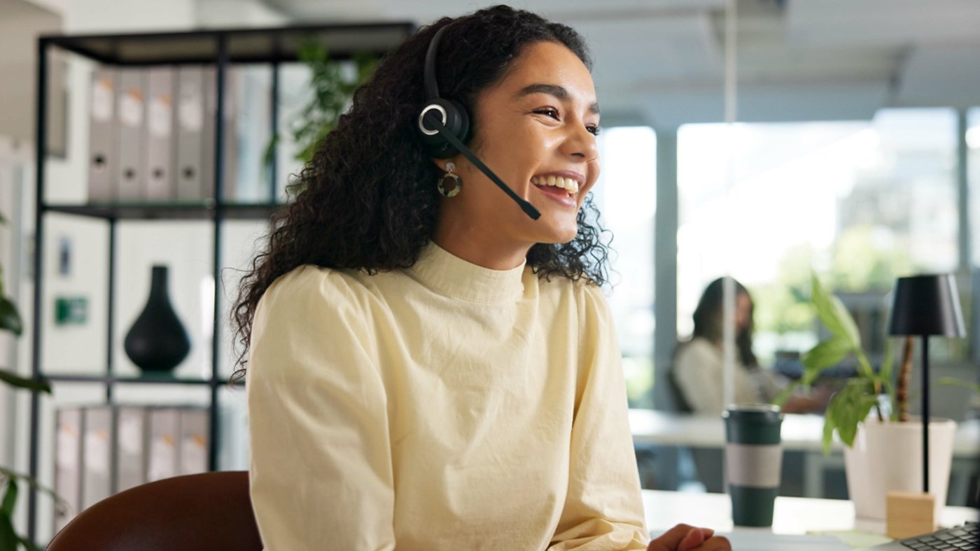 Laughing, happy woman and customer service in call center with agent, communication and online consulting. Funny joke, friendly consultant and sales office for CRM contact support, advice or business.