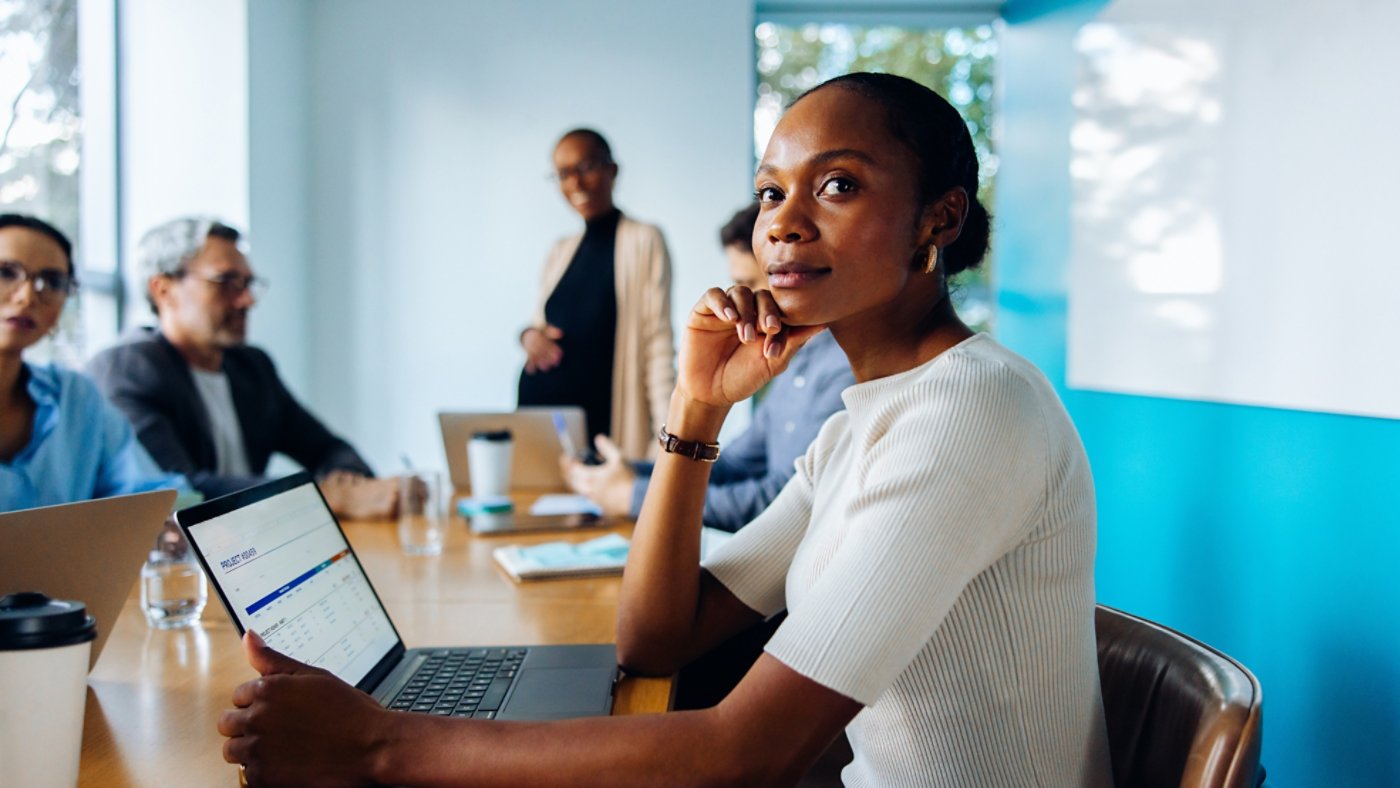 Group discussing in an office featuring a focus on a thoughtful female professional