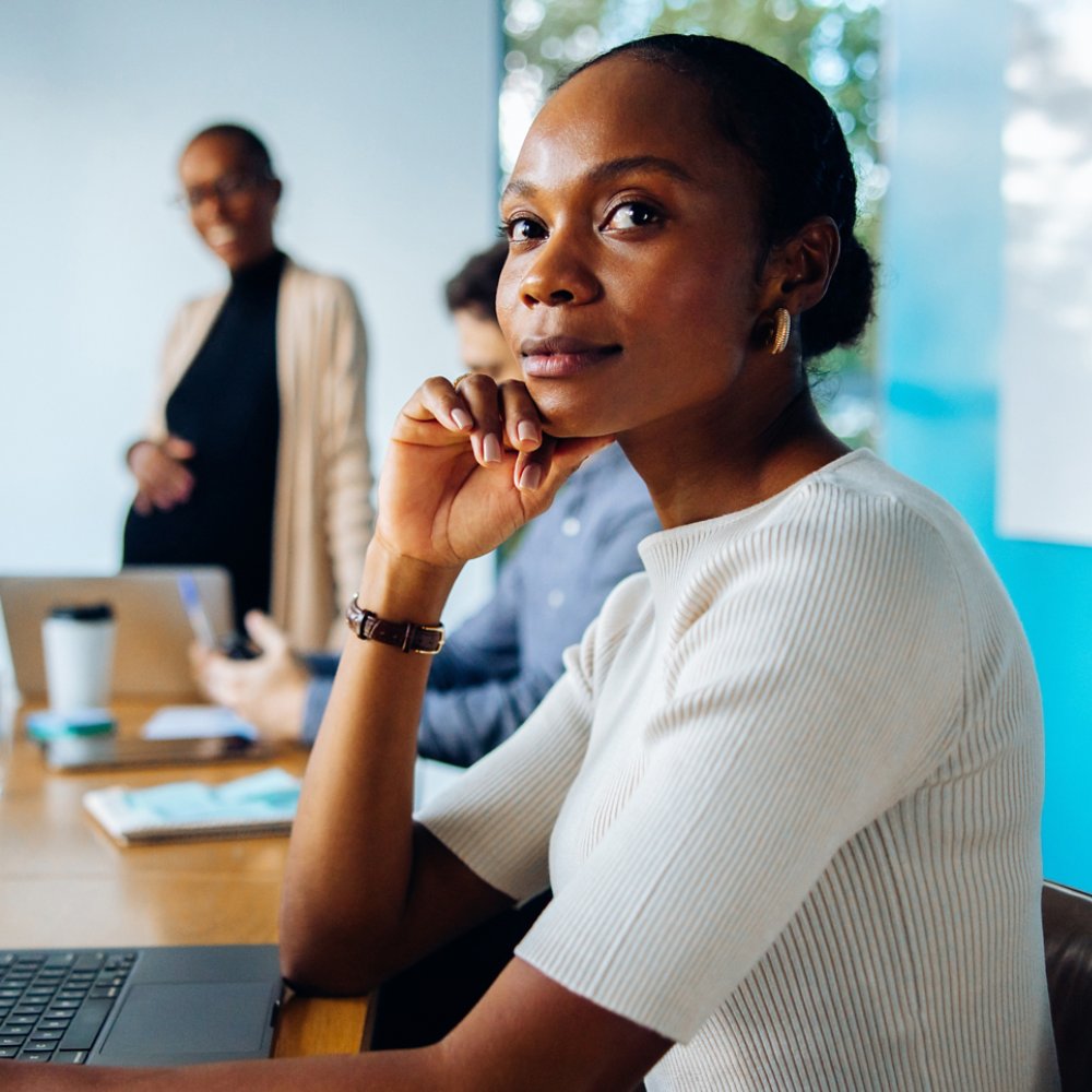 Group discussing in an office featuring a focus on a thoughtful female professional