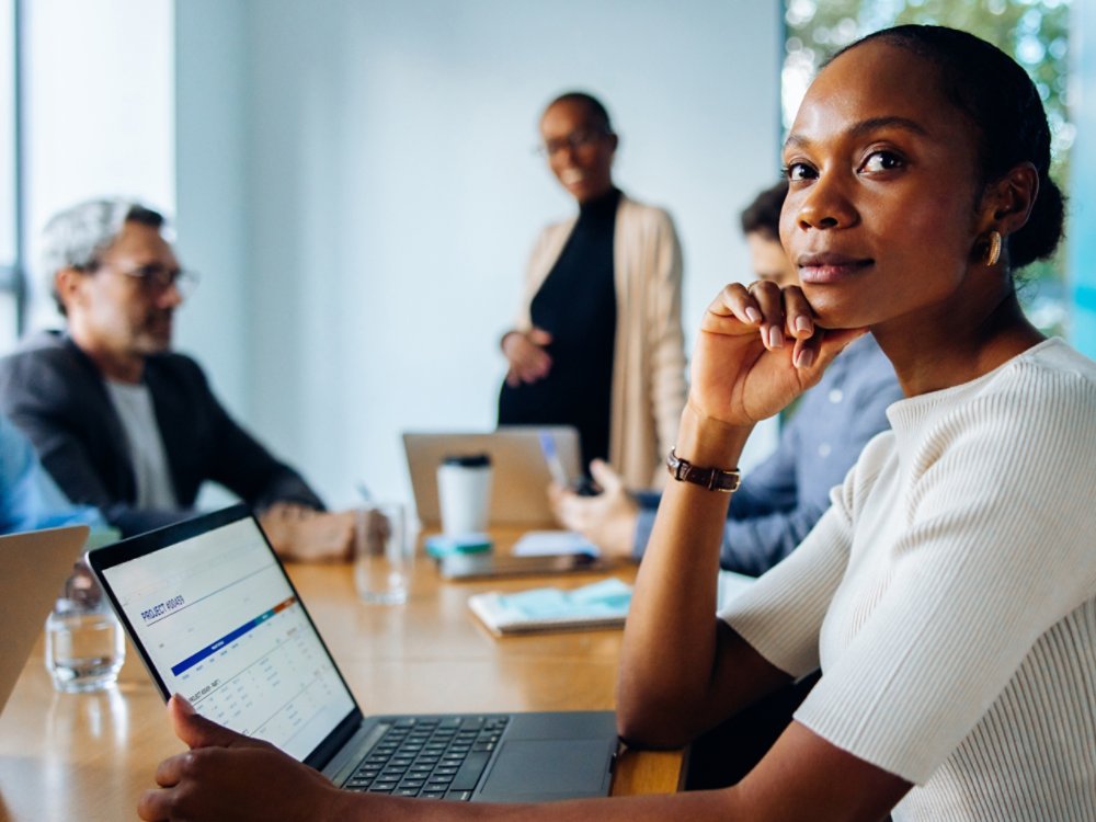Group discussing in an office featuring a focus on a thoughtful female professional