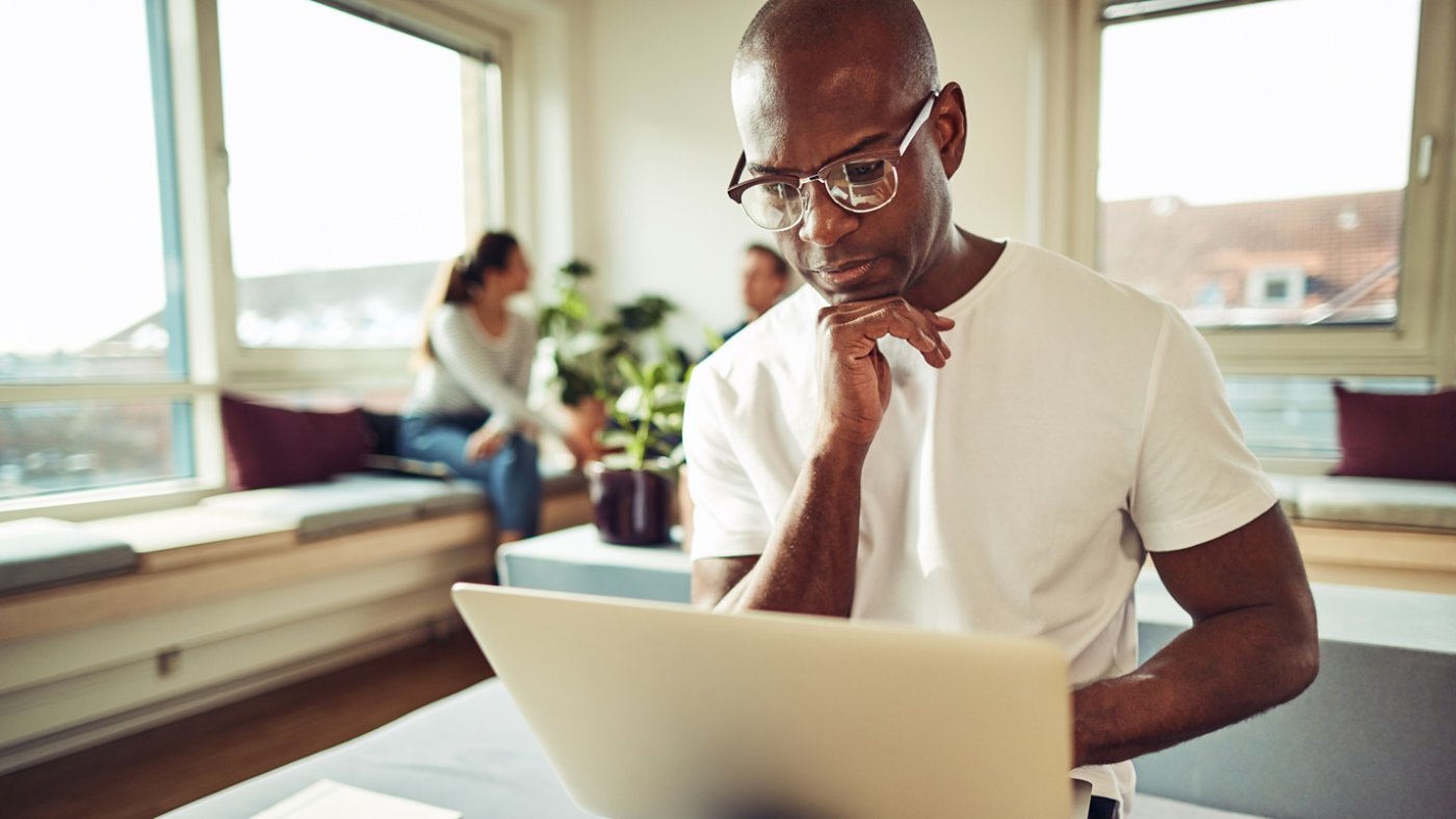 Focused African businessman working online with colleagues in th