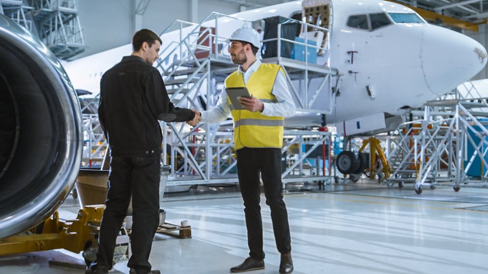 Engineer moving though Aircraft Maintenance Terminal Greeting a Mechanic