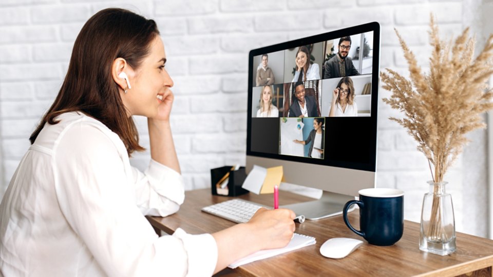 Video call. Remote work. A girl work from home. She communicate via video communication with colleagues using computer - 16x9