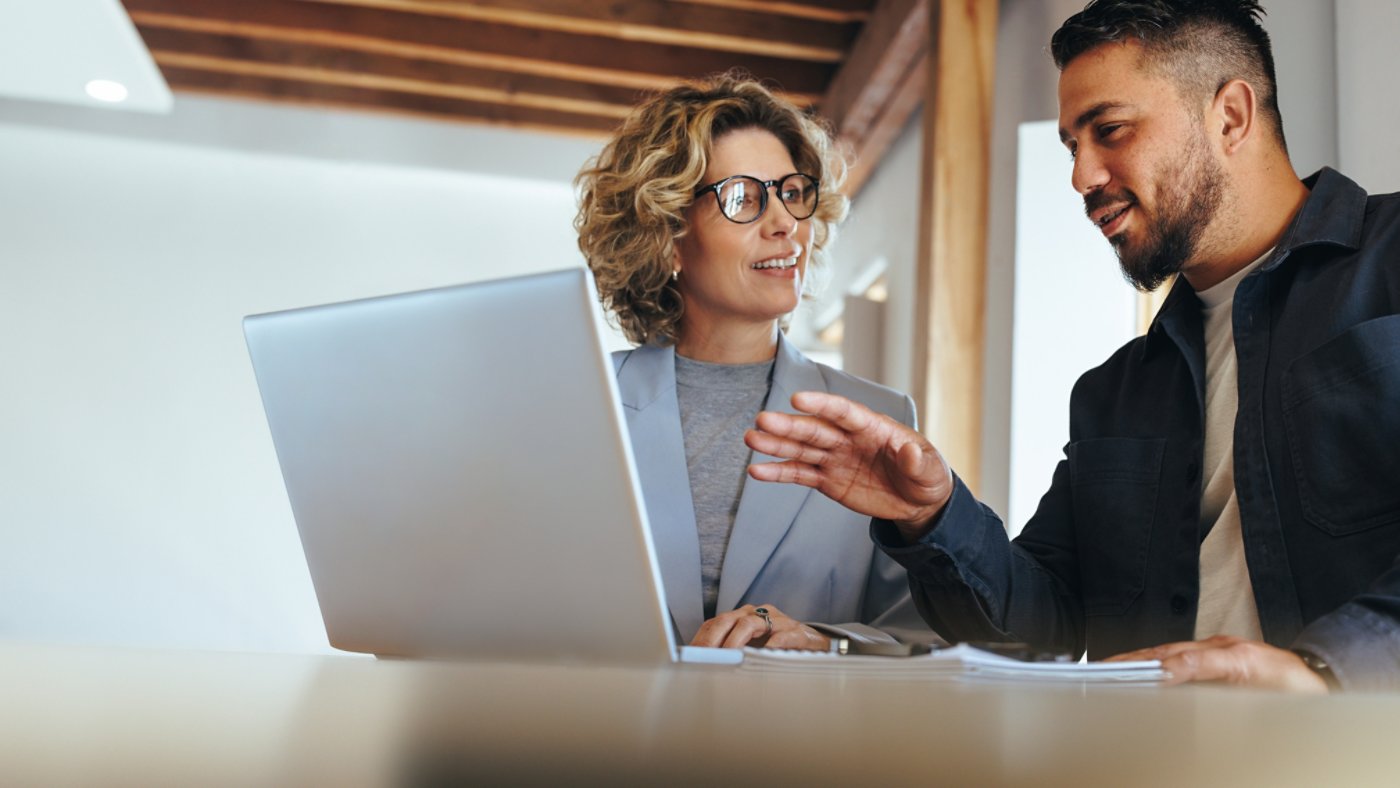 two coworkers discussing a project in the office