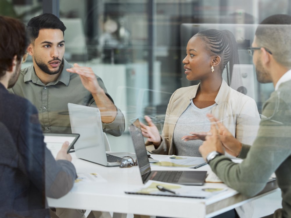 Meeting, collaboration and business people in discussion in the office while working together. Teamwork, planning and group of employees brainstorming with technology for a project in the workplace.