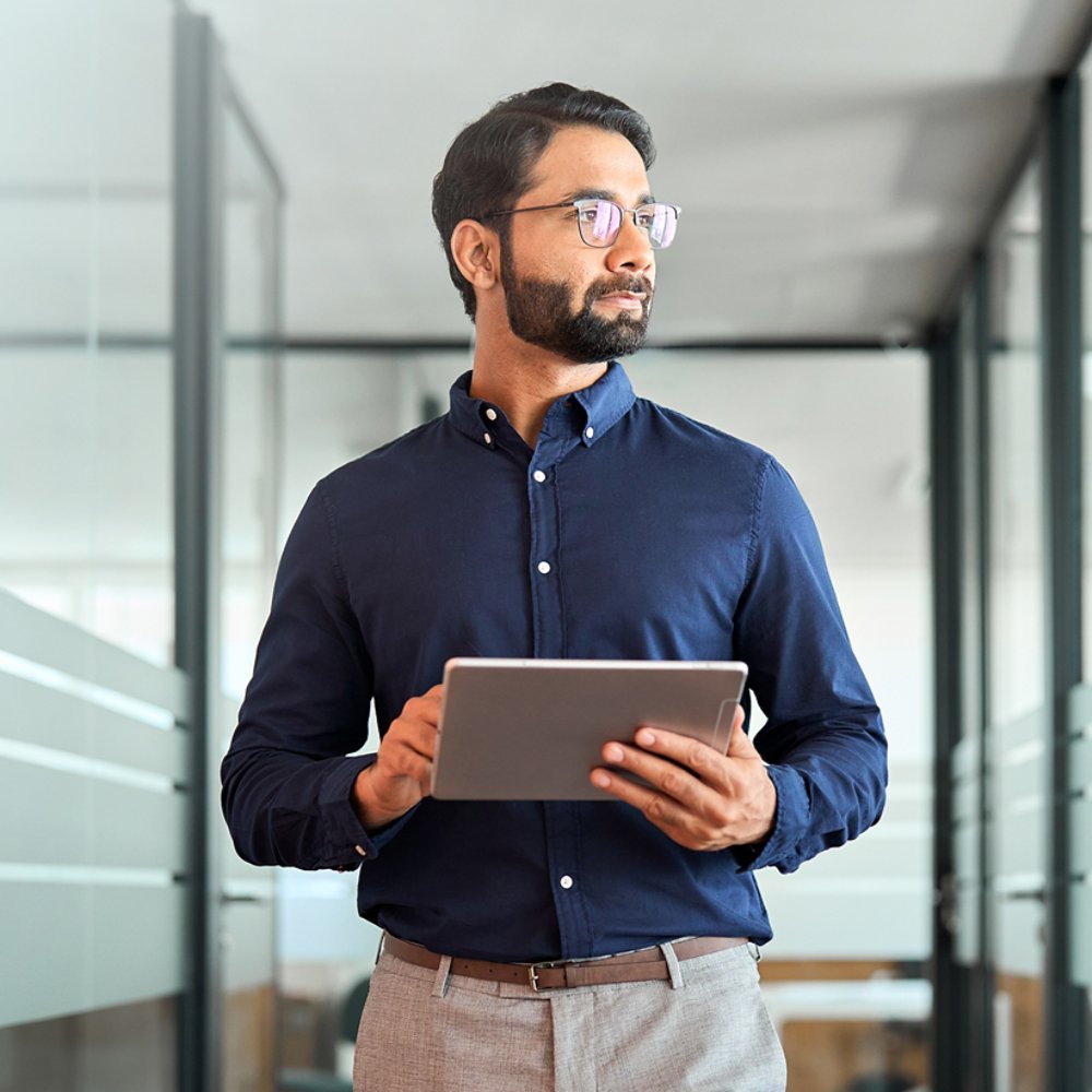 Man walking down hall with tablet in hands - 21x9 version