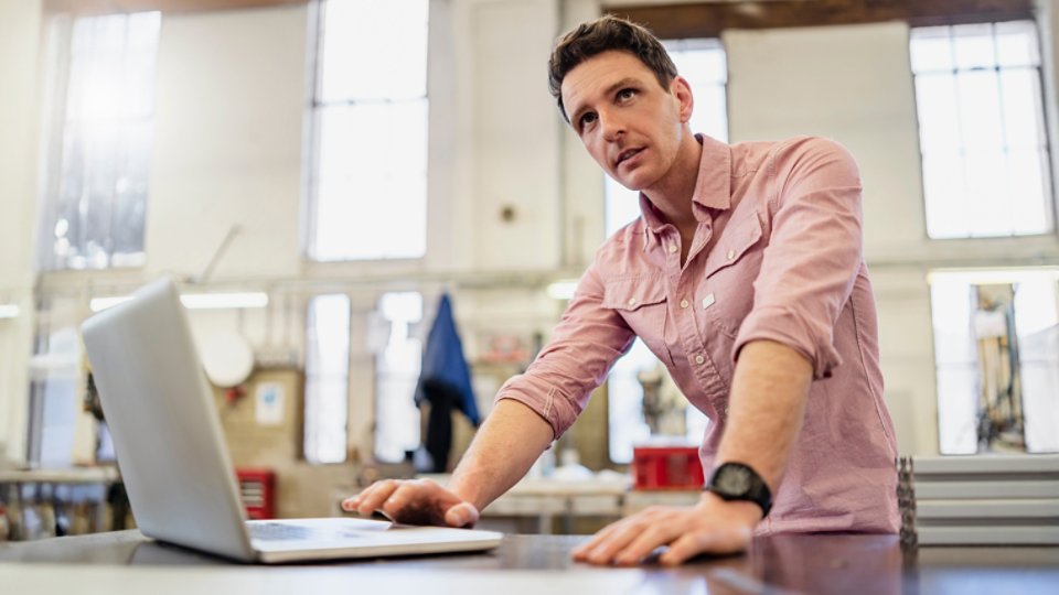 Man using laptop in factory