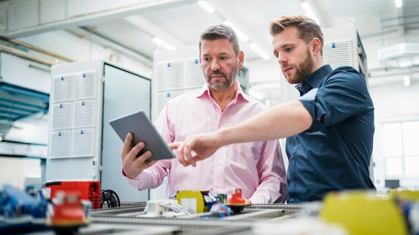 Two men with tablet having a work meeting in a factory