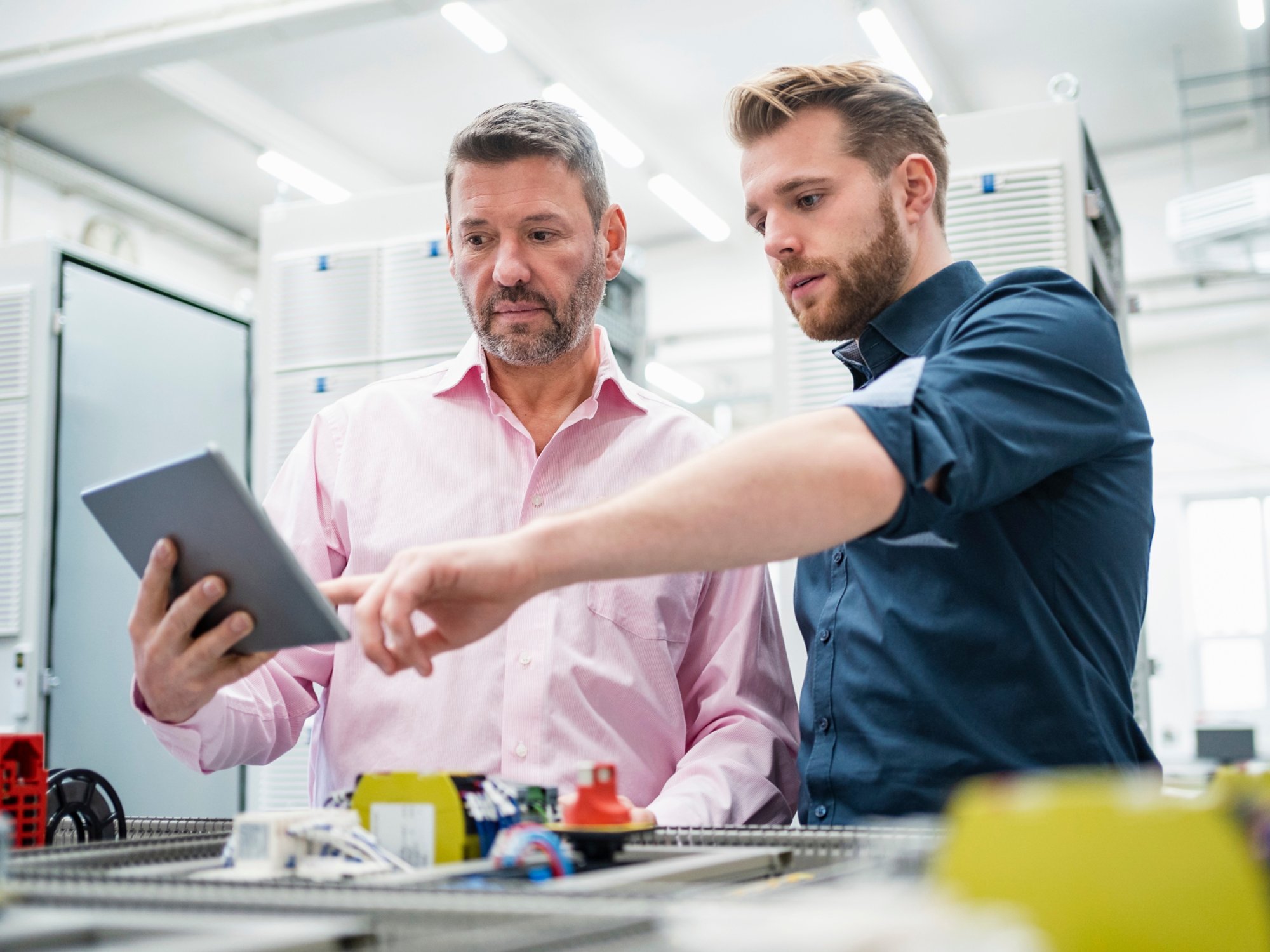 Two men with tablet having a work meeting in a factory